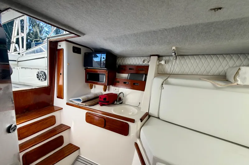 Slide: The Image of Interior of 2002 Contender 35 Side Console boat with wooden steps and compact amenities. - 13