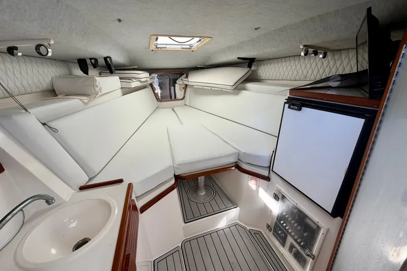 Slide: The Image of Interior of 2002 Contender 35 Side Console boat, featuring compact bathroom with sink and toilet. - 14