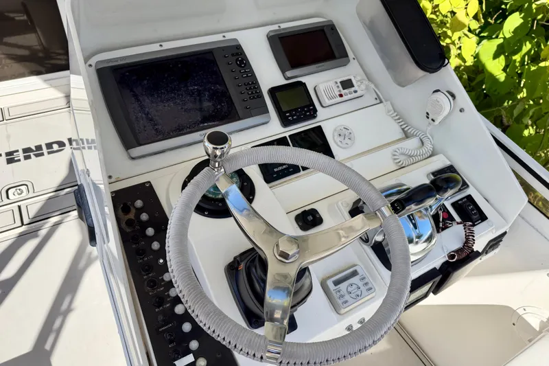 Slide: The Image of 2002 Contender 35 Side Console boat on trailer, surrounded by lush greenery. - 6