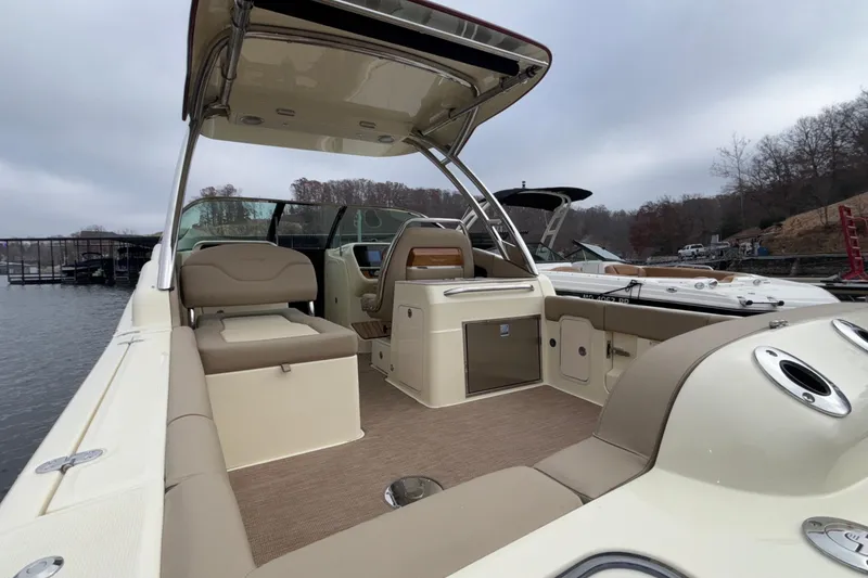 Slide: The Image of 2026 Chris-Craft Calypso 28 boat interior with seating and helm, docked on a cloudy day. - 10