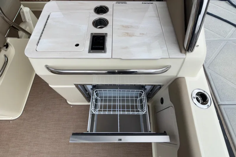 Slide: The Image of 2026 Chris-Craft Calypso 28 boat interior with open drawer and Kenyon cooktop. - 20