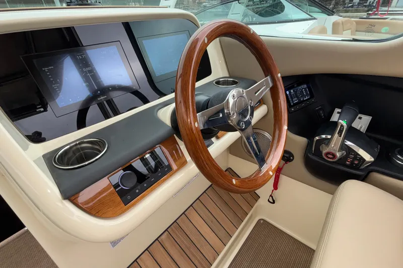 Slide: The Image of 2026 Chris-Craft Calypso 28 helm with wooden steering wheel and modern controls. - 27