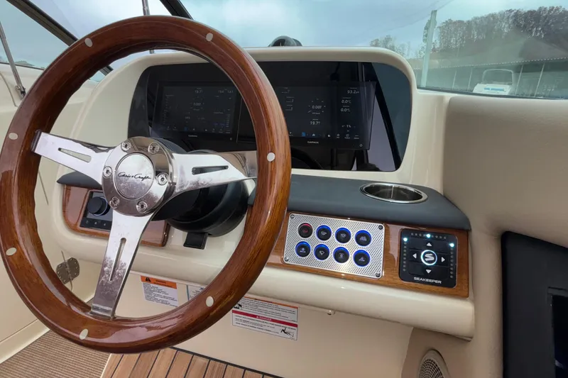 Slide: The Image of 2026 Chris-Craft Calypso 28 helm with wooden steering wheel and modern controls. - 30