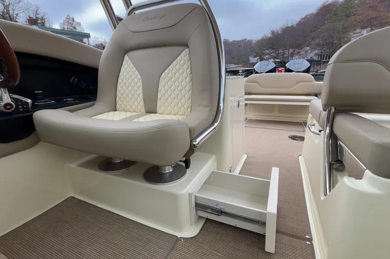 Slide: The Image of 2026 Chris-Craft Calypso 28 interior with beige seating and storage drawer. - 33