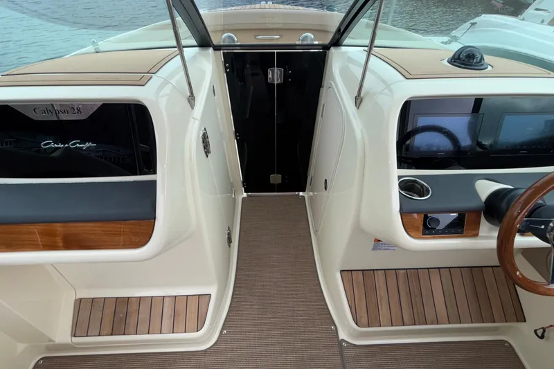 Slide: The Image of 2026 Chris-Craft Calypso 28 boat interior with modern dashboard and wooden accents. - 36