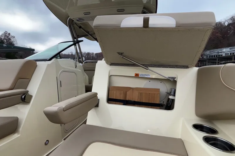 Slide: The Image of 2026 Chris-Craft Calypso 28 interior with open storage compartment and beige seating. - 47