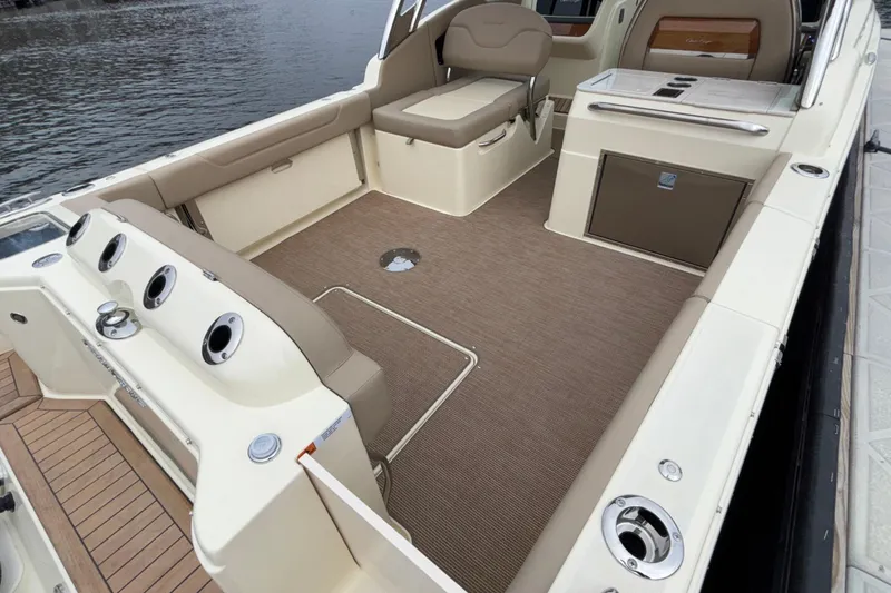 Slide: The Image of 2026 Chris-Craft Calypso 28 boat interior with seating and storage, docked by the water. - 5