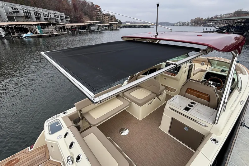 Slide: The Image of 2026 Chris-Craft Calypso 28 boat with retractable sunshade on a calm lake. - 60