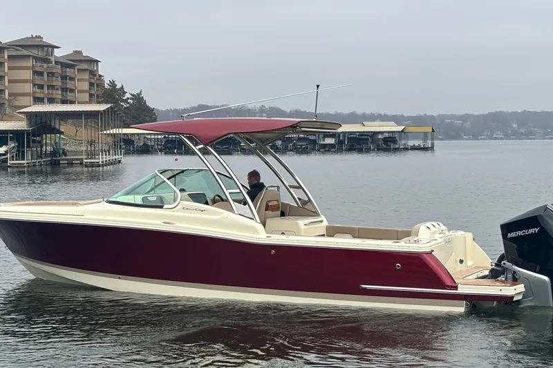 Slide: The Image of 2026 Chris-Craft Calypso 28 boat on a calm lake near docks and buildings. - 62