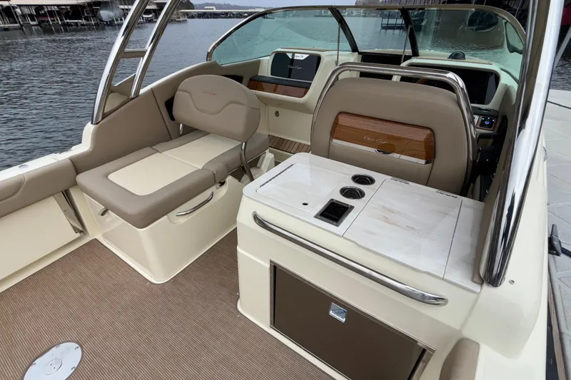 Slide: The Image of 2026 Chris-Craft Calypso 28 boat interior with seating and control panel, docked by the water. - 7