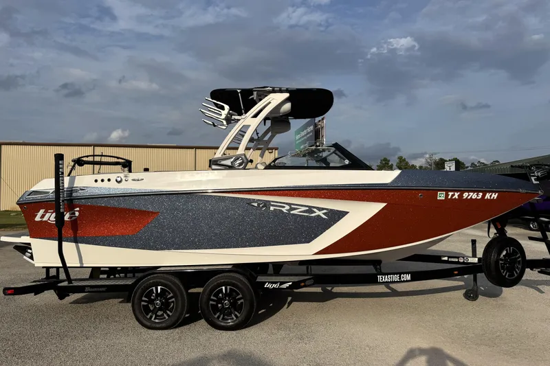 Slide: The Image of 2021 Tigé 23RZX boat on trailer, featuring sleek design and vibrant colors. - 1