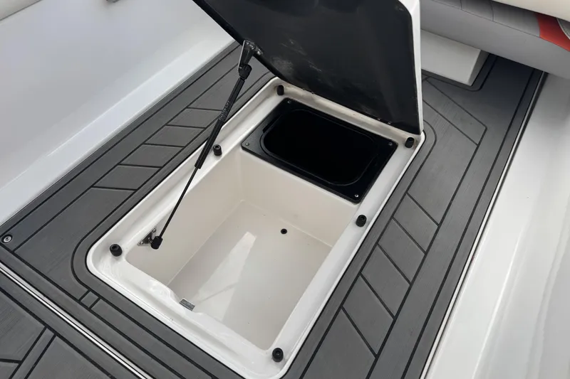 Slide: The Image of Open storage compartment on 2021 Tigé 23RZX boat with gray flooring. - 12
