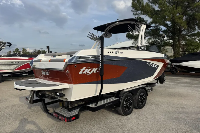 Slide: The Image of 2021 Tigé 23RZX boat on trailer, featuring sleek design and vibrant colors. - 2