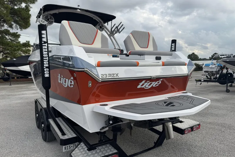 Slide: The Image of 2021 Tigé 23RZX boat with red and white design, parked on a trailer. - 5