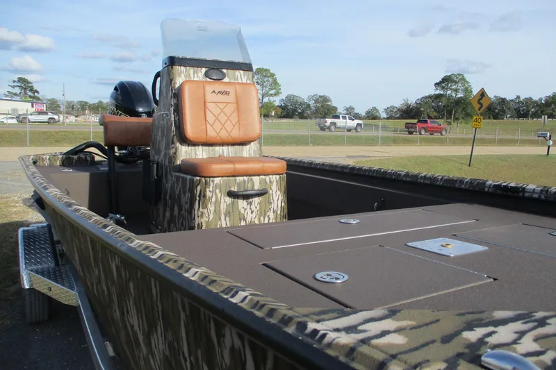 Slide: The Image of 2026 Avid 18 Rogue CC boat with camouflage design and brown seating, parked outdoors. - 5