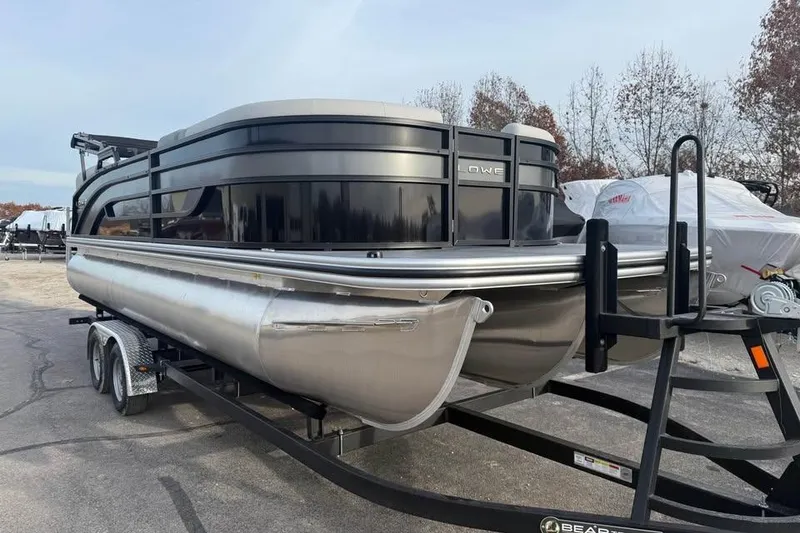 Slide: The Image of 2026 Lowe SS 230 WV pontoon boat on a trailer, parked outdoors. - 1