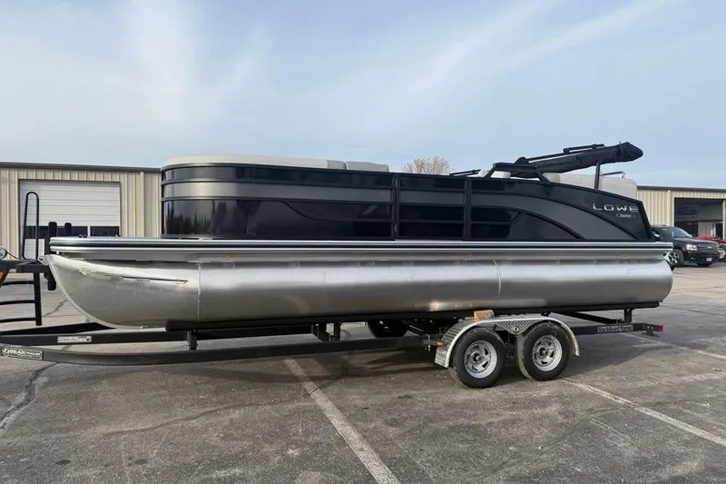 Slide: The Image of 2026 Lowe SS 230 WV pontoon boat on a trailer in a parking lot. - 4