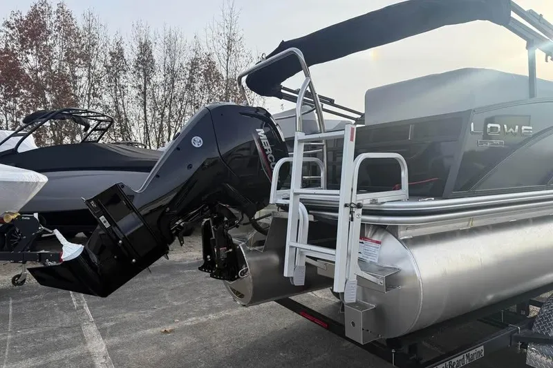 Slide: The Image of 2026 Lowe SS 230 WV pontoon boat with Mercury outboard motor, parked outdoors. - 5