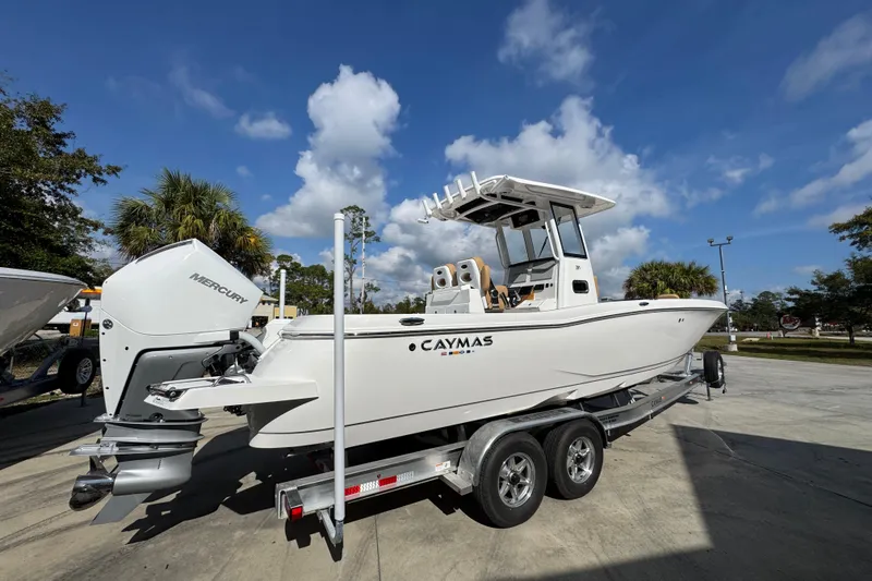Slide: The Image of 2026 Caymas 291 boat on trailer, featuring Mercury outboard motor, under a clear blue sky. - 12