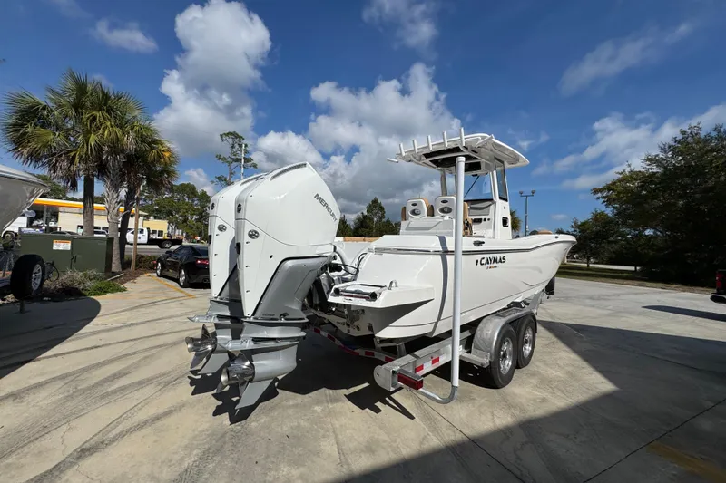 Slide: The Image of 2026 Caymas 291 boat on trailer, featuring dual Mercury outboard engines, parked outdoors. - 13