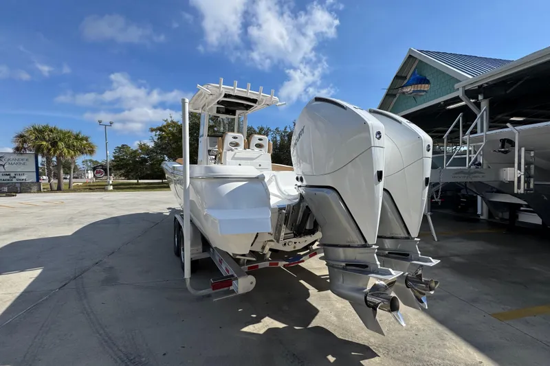 Slide: The Image of 2026 Caymas 291 boat with dual outboard engines in a marina setting. - 16