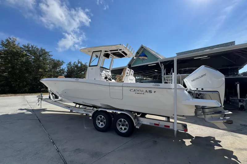 Slide: The Image of 2026 Caymas 291 boat on trailer, parked outdoors under clear blue sky. - 18