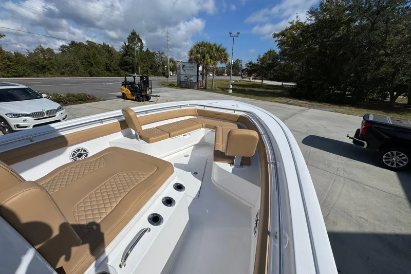 Slide: The Image of 2026 Caymas 291 boat with tan seating, parked outdoors under a blue sky. - 19