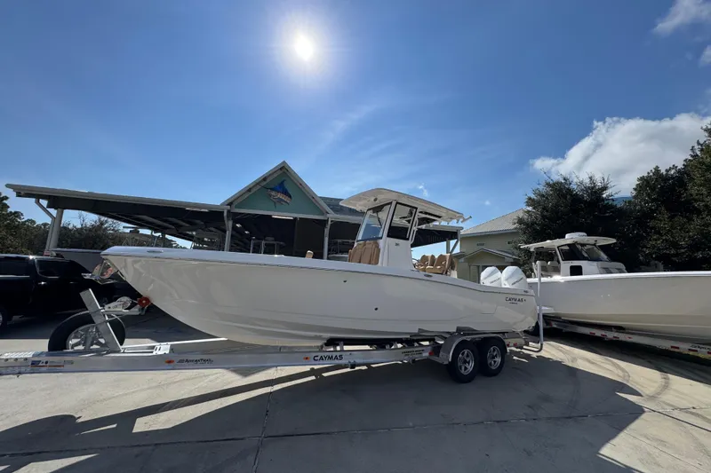 Slide: The Image of 2026 Caymas 291 boat on trailer under sunny sky, parked near a house. - 3