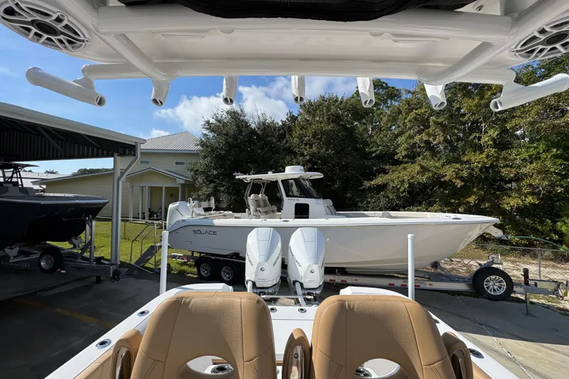 Slide: The Image of 2026 Caymas 291 boat with dual engines, parked on a trailer in a sunny outdoor setting. - 30