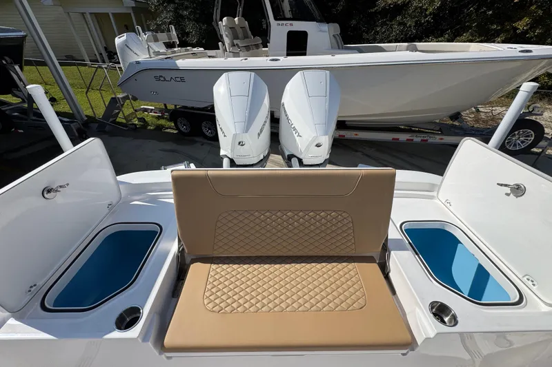 Slide: The Image of 2026 Caymas 291 boat with dual Mercury engines and tan seating, featuring storage compartments. - 43