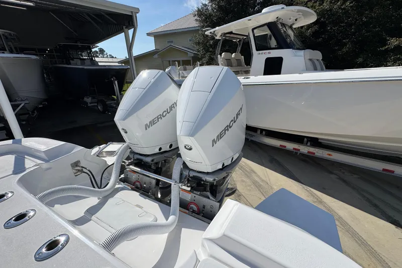 Slide: The Image of 2026 Caymas 291 boat with dual Mercury outboard engines, parked near another boat. - 44