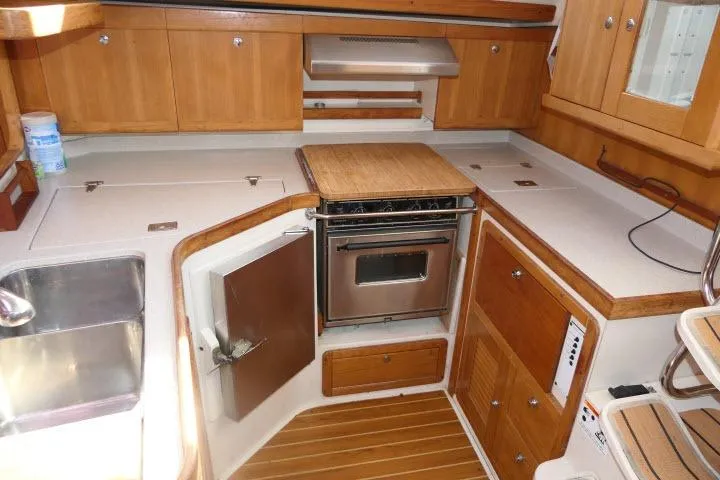 Slide: The Image of 2008 Catalina 400 MK II yacht kitchen with wooden cabinets and stainless steel appliances. - 13