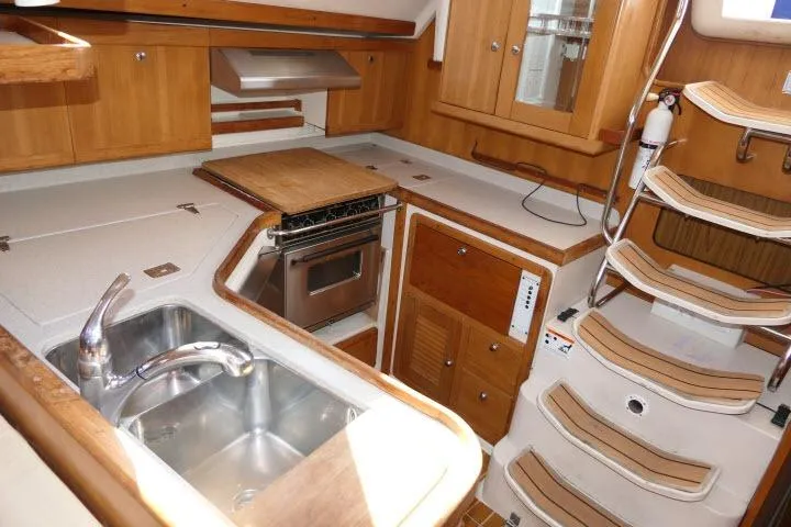 Slide: The Image of Interior of 2008 Catalina 400 MK II yacht kitchen with wooden cabinetry and stainless steel sink. - 14