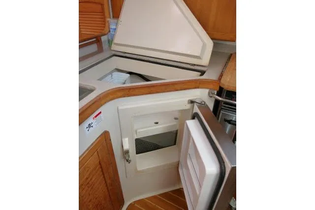 Slide: The Image of 2008 Catalina 400 MK II yacht kitchen with open fridge and storage compartments. - 16