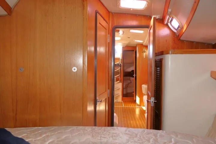 Slide: The Image of Interior of 2008 Catalina 400 MK II sailboat, featuring wooden paneling and cozy cabin layout. - 23