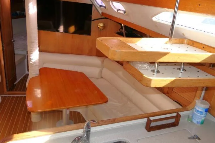 Slide: The Image of Interior of 2008 Catalina 400 MK II sailboat with wooden table and seating area. - 6