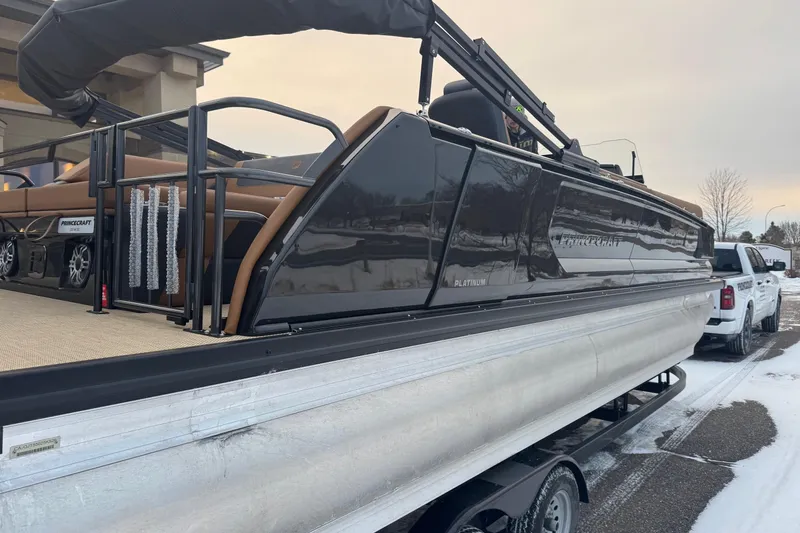 Slide: The Image of 2026 Princecraft Vogue 25 pontoon boat on trailer, parked in snowy area. - 2