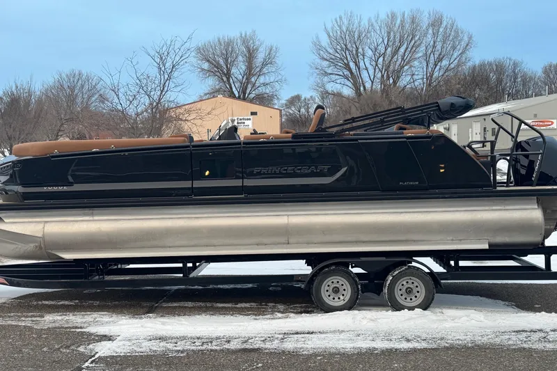 Slide: The Image of 2026 Princecraft Vogue 25 pontoon boat on trailer, winter setting, trees in background. - 7
