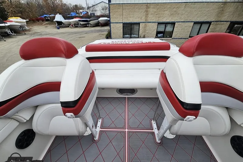 Slide: The Image of 2004 Black Thunder 460 boat interior with red and white seating, docked outdoors. - 100