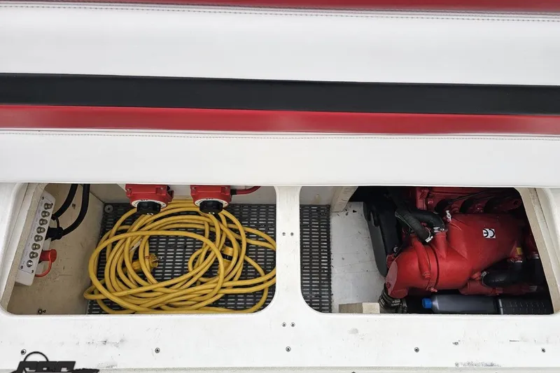 Slide: The Image of Engine compartment of a 2004 Black Thunder 460 boat with coiled yellow cables. - 106
