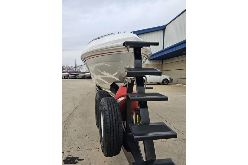 Slide: The Image of 2004 Black Thunder 460 boat on trailer, parked outside a building. - 11