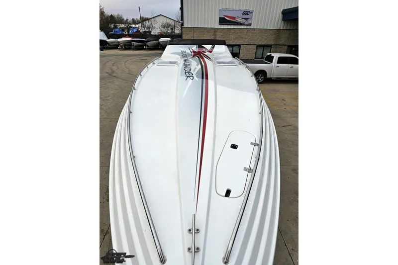 Slide: The Image of 2004 Black Thunder 460 boat with sleek white design and red accents, docked outdoors. - 13