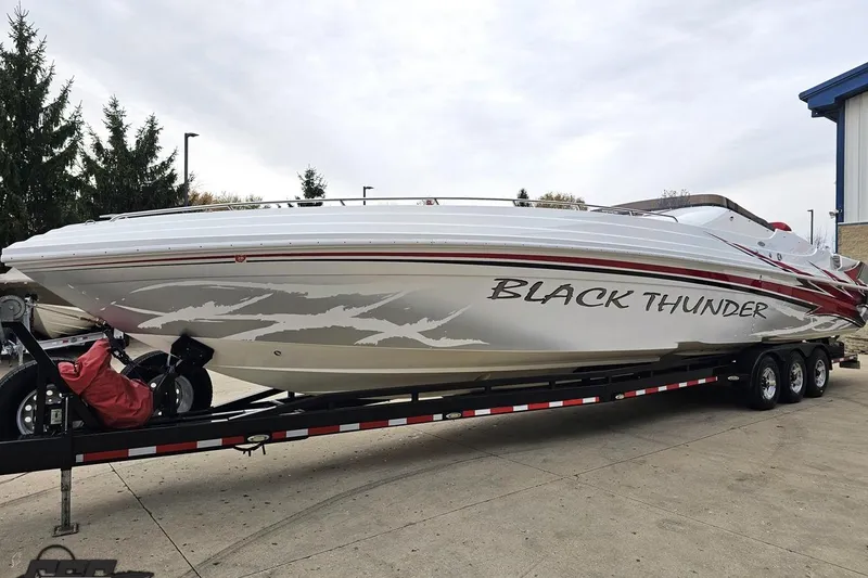 Slide: The Image of 2004 Black Thunder 460 powerboat on trailer, sleek design with bold graphics. - 15