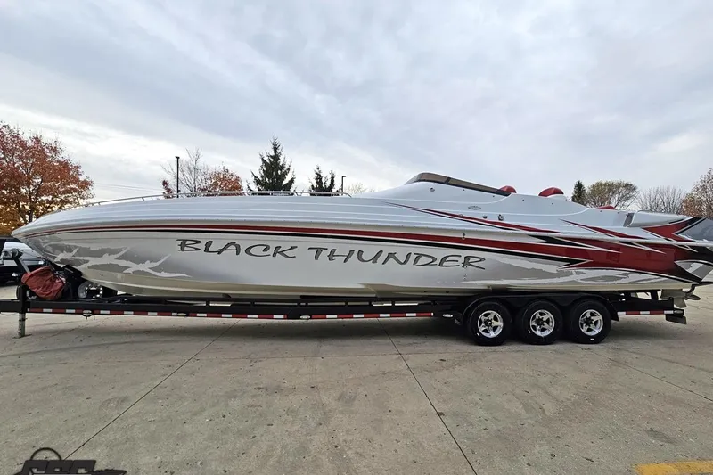 Slide: The Image of 2004 Black Thunder 460 powerboat on trailer, featuring sleek design and bold graphics. - 16