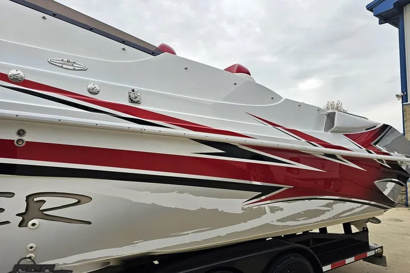 Slide: The Image of 2004 Black Thunder 460 boat with red and black graphics on a trailer. - 19