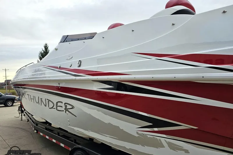 Slide: The Image of 2004 Black Thunder 460 boat with red and white design on a trailer. - 23