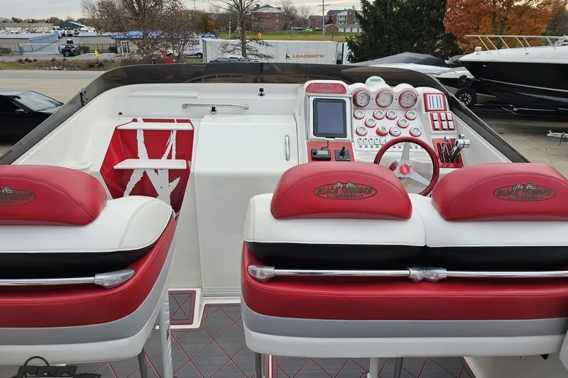 Slide: The Image of Interior of a 2004 Black Thunder 460 boat with red and white seating and control panel. - 51