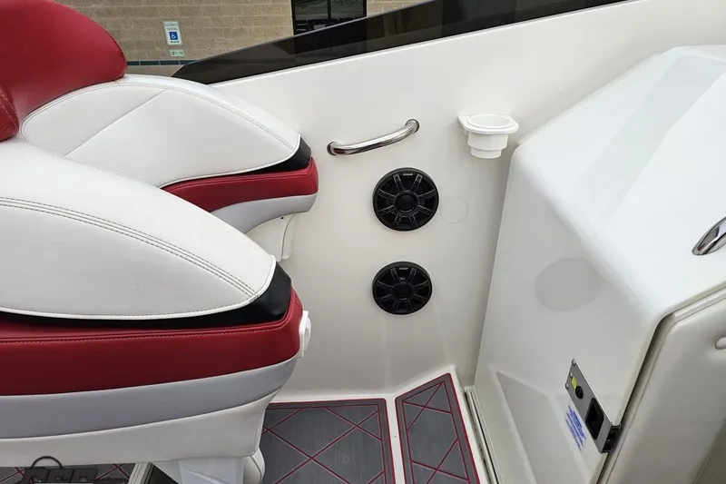 Slide: The Image of Interior of 2004 Black Thunder 460 boat with red and white seating, speakers, and cup holder. - 52
