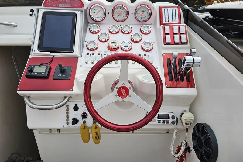 Slide: The Image of Dashboard of a 2004 Black Thunder 460 powerboat with red accents and multiple gauges. - 55