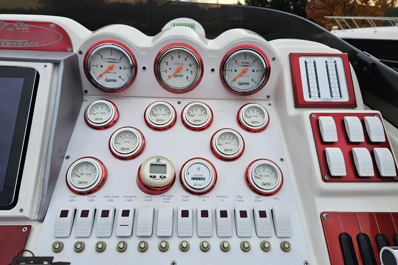 Slide: The Image of Control panel of a 2004 Black Thunder 460 boat with gauges and switches. - 57